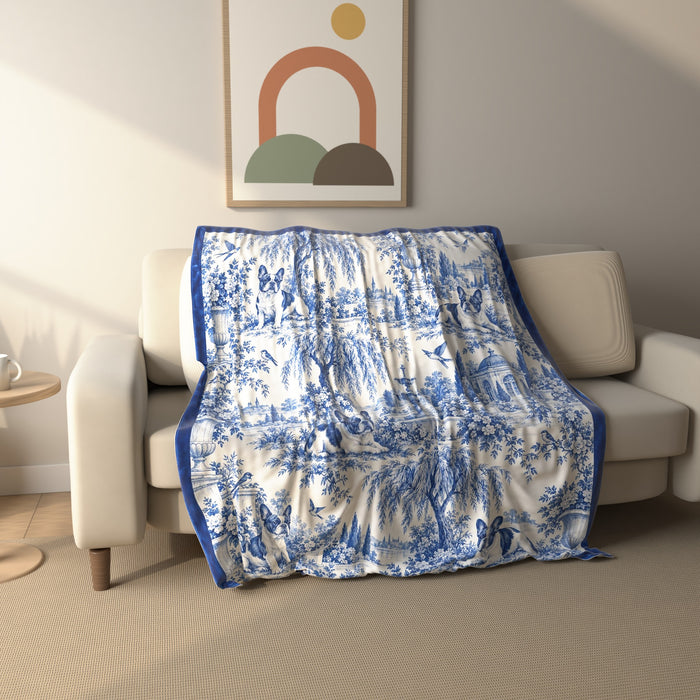 Blue Toile French Bulldog fleece throw blanket draped over a sofa