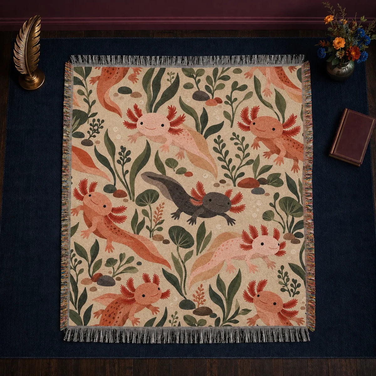 Terracotta Modern Axolotl woven throw blanket — peach, terracotta and charcoal axolotls among olive leaves and pebbles on warm sand