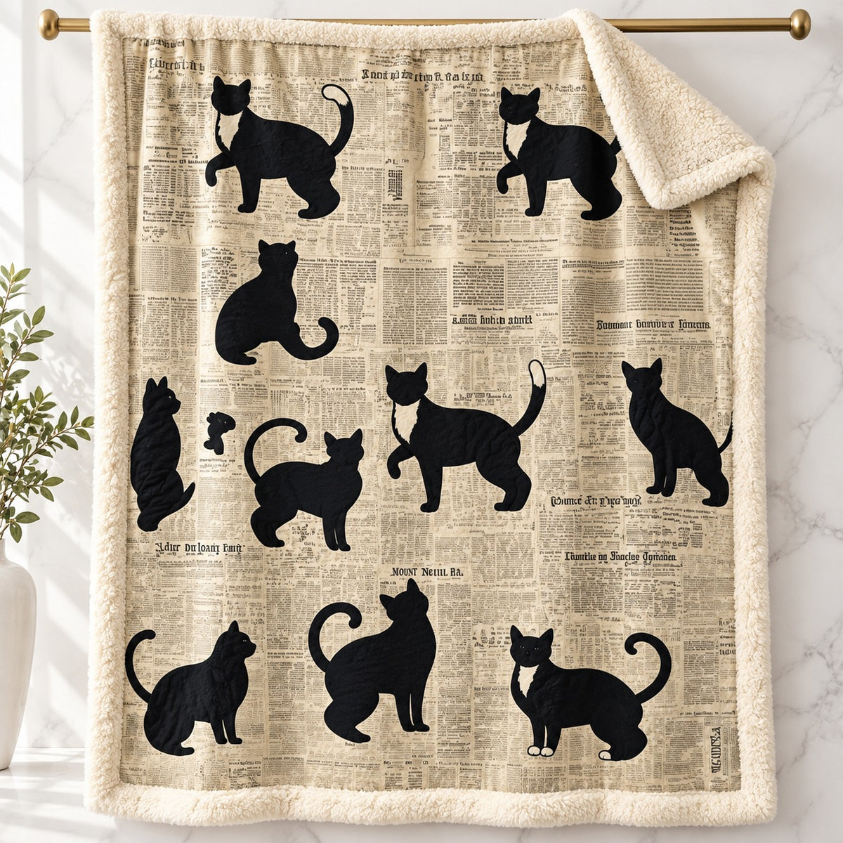 Newsprint Black Cats sherpa fleece blanket – printed flannel front with plush cream sherpa back, hanging on a gold rod