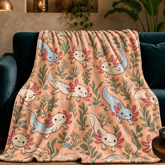 Whimsical Contour Axolotl fleece throw blanket — cream and powder blue cartoon axolotls with sage leaves and bubbles on apricot