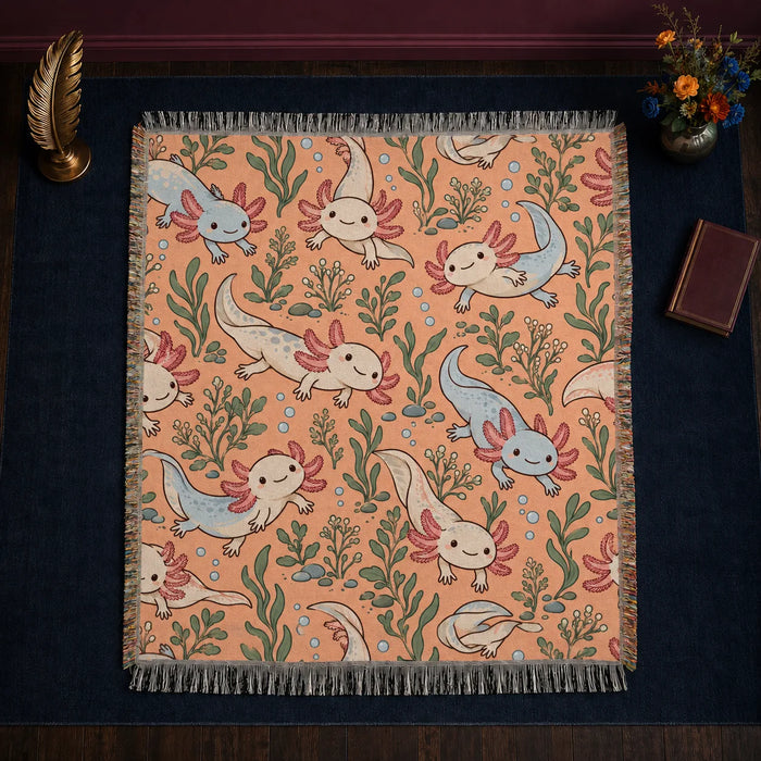 Whimsical Contour Axolotl woven throw blanket — cream and powder blue cartoon axolotls with sage leaves and bubbles on apricot