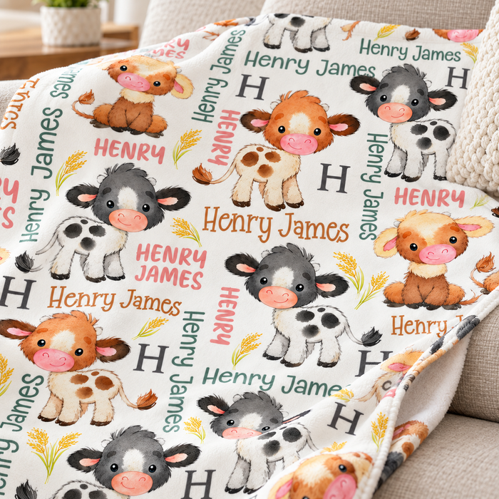 Baby cow personalised name blanket with watercolour calves, on a sofa