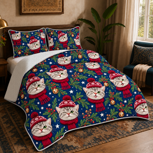 Navy Christmas Cat Faces quilt set on a made bed — quilt with two matching pillow shams. Cat faces in red bobble hats and scarves, scattered over navy.