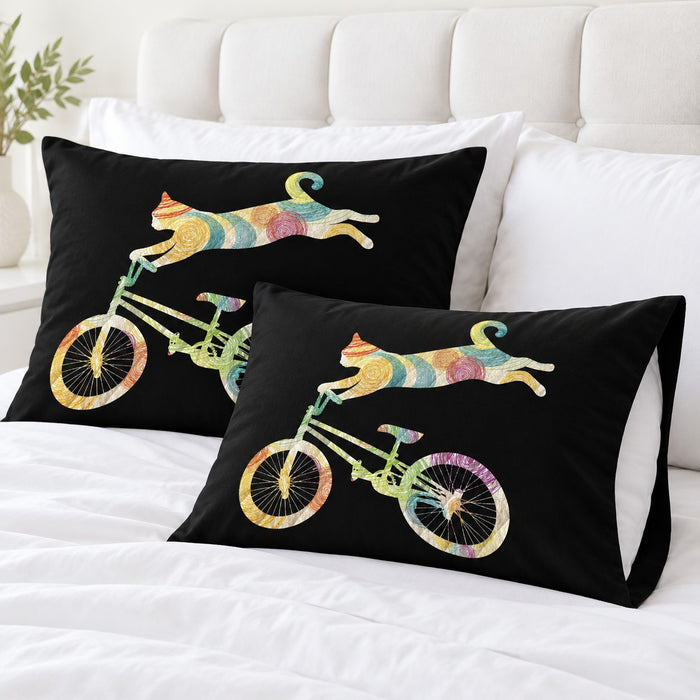 Rainbow Cycling Cat pillowcases – set of two printed envelope pillowcases on a white bed