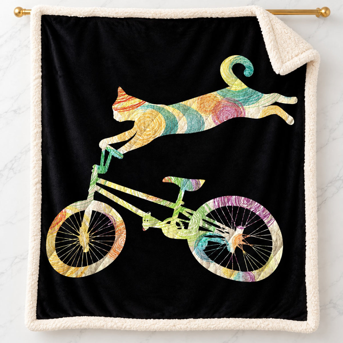 Rainbow Cycling Cat sherpa fleece blanket – printed flannel front with plush cream sherpa back, hanging on a gold rod